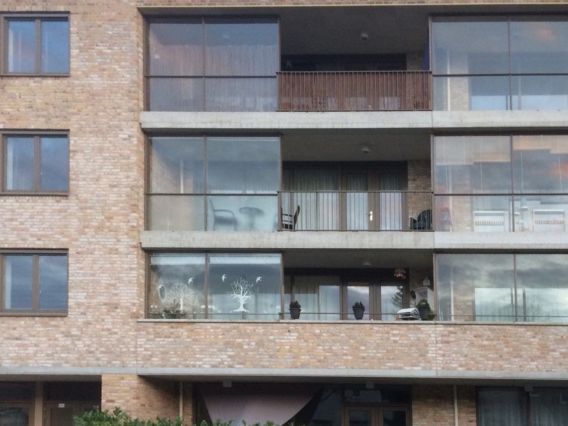 Appartementengebouw van baksteen met opnieuw geschilderde bruine kozijnen en balkonpuien, schilderwerk van M.C.M.Totaalonderhoud